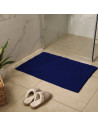 tapis de bain bleu posé sur carrelage salle de bains