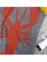 serviette de plage homard posée sur le sable