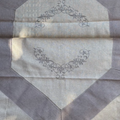 zoom details des broderies du chemin de table nuance de gris en coton, lin et polyester. chic et sobre